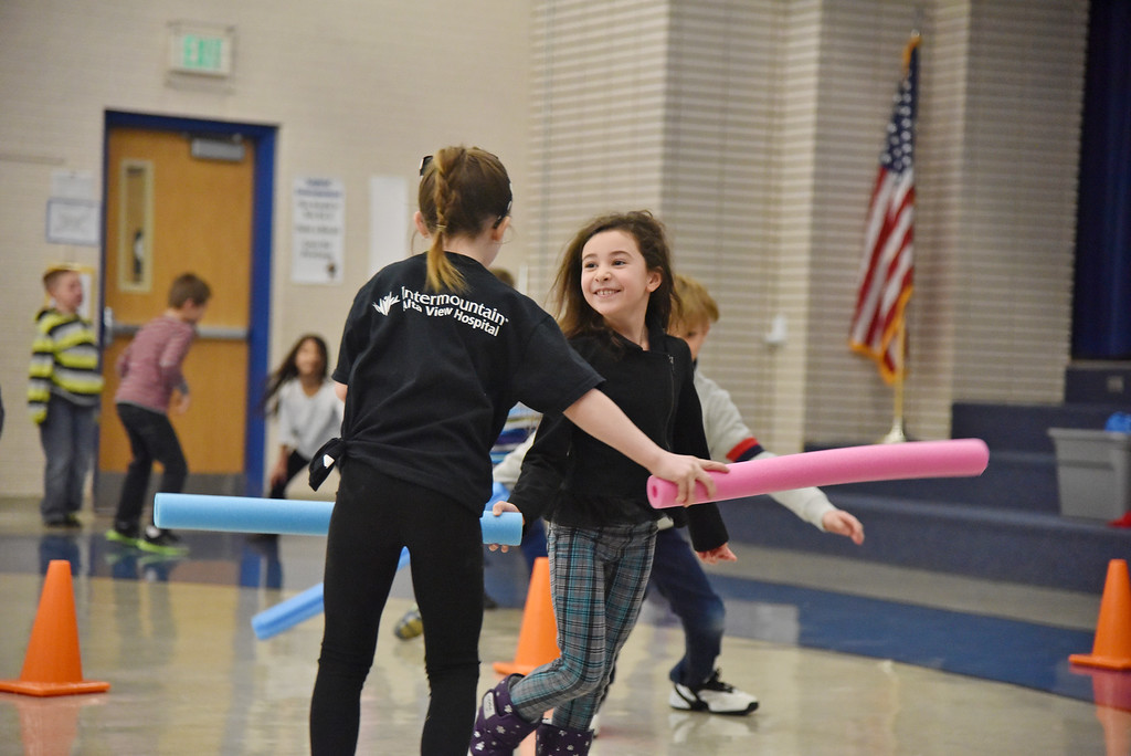 students playing with pool noodles